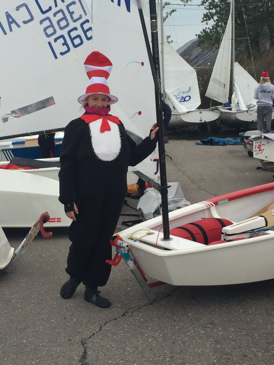 Annie in a Cat in the Hat costume beside her Optimist dinghy.